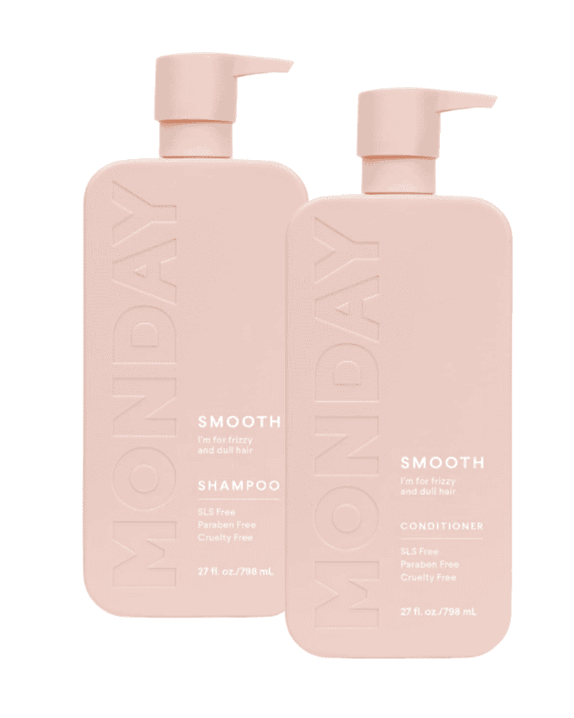 Two pink bottles of MONDAY haircare products: one shampoo and one conditioner, labeled "Smooth" for frizzy and dull hair. Each is a beauty essential at 27 fl oz (796 mL), marked as SLS, paraben, and cruelty-free.