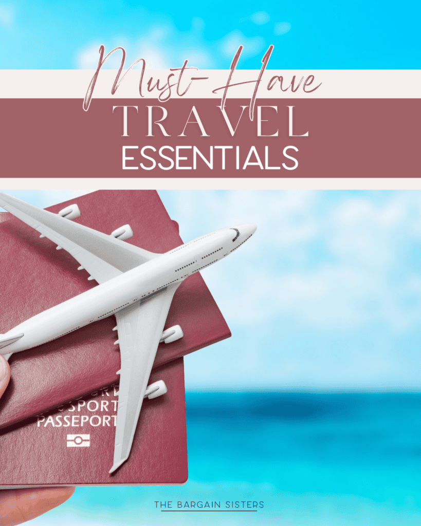 A hand holds two red passports and a white toy airplane against a blurred backdrop of blue sky and ocean. Text reads "Must-Have Travel Essentials" by The Bargain Sisters.