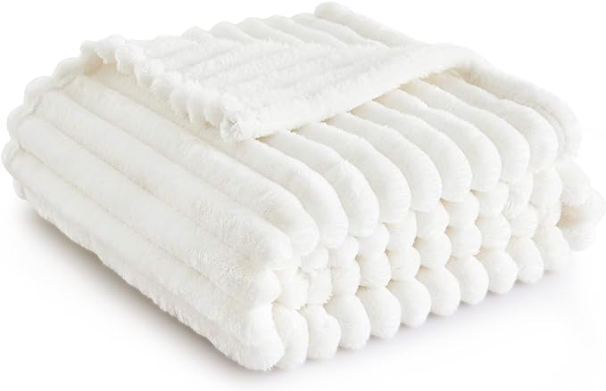 Displayed on a plain background, this neatly folded, plush white blanket with a ribbed texture exudes comfort and warmth. Take advantage of our exclusive Tuesday Deals to bring this inviting piece into your home today.