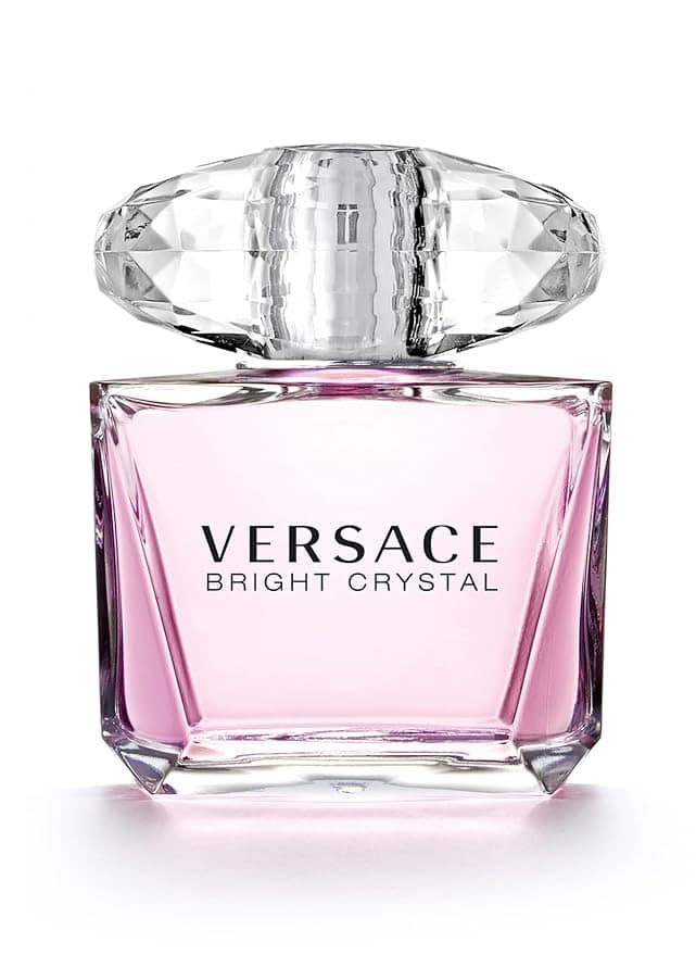 A bottle of Versace Bright Crystal perfume, perfect for Tuesday Deals. The transparent bottle with light pink liquid is topped by a large, faceted clear cap. Bold black letters spell "VERSACE BRIGHT CRYSTAL" on the front, capturing elegance and allure in every glance.