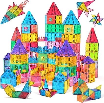 A colorful castle made of translucent magnetic tiles in various shapes and sizes, surrounded by tile creations like rockets, animals, and stars. The vibrant colors include red, blue, yellow, green, pink, and purple. Don't miss out on these imaginative sets with Thursday Deals!