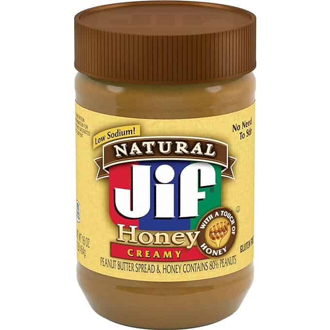 A jar of Jif Natural Honey Creamy Peanut Butter is shown, perfect for your Wednesday Deals. The label highlights "low sodium," "with a touch of honey," "no need to stir," and "gluten-free." The 16-ounce jar boasts 80% peanuts, offering a deliciously smooth experience.