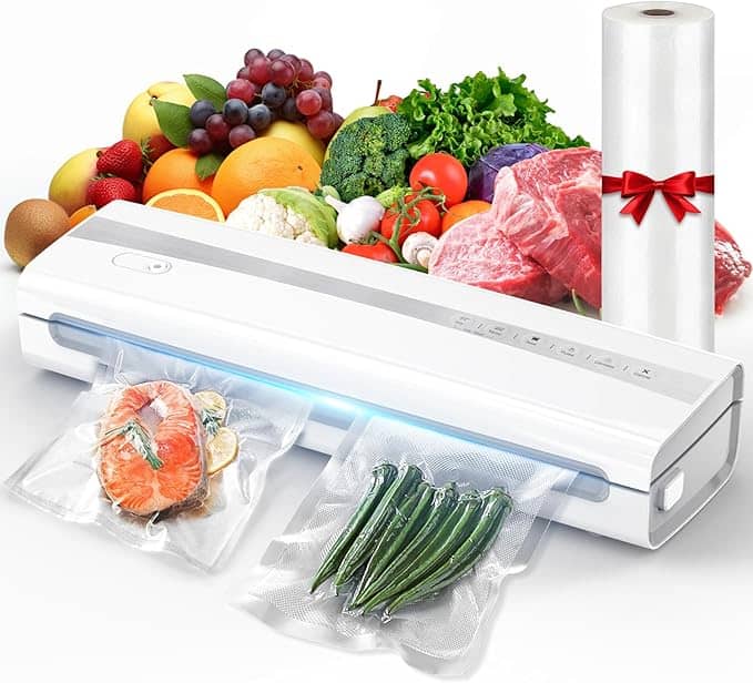 A vacuum sealer on a table with sealed bags of salmon and green beans in front. Behind it, an assortment of fresh produce awaits its turn, including fruits, vegetables, and meats. A roll of vacuum sealing bags sits nearby—perfect for making the most out of those irresistible Friday Deals.