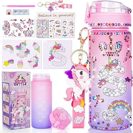 A vibrant water bottle adorned with rhinestones and a unicorn design. Accessories feature keychains, stickers with motivational words, and various unicorn and rainbow images, all set against a pink and purple theme. Perfect for grabbing during the Friday Deals!