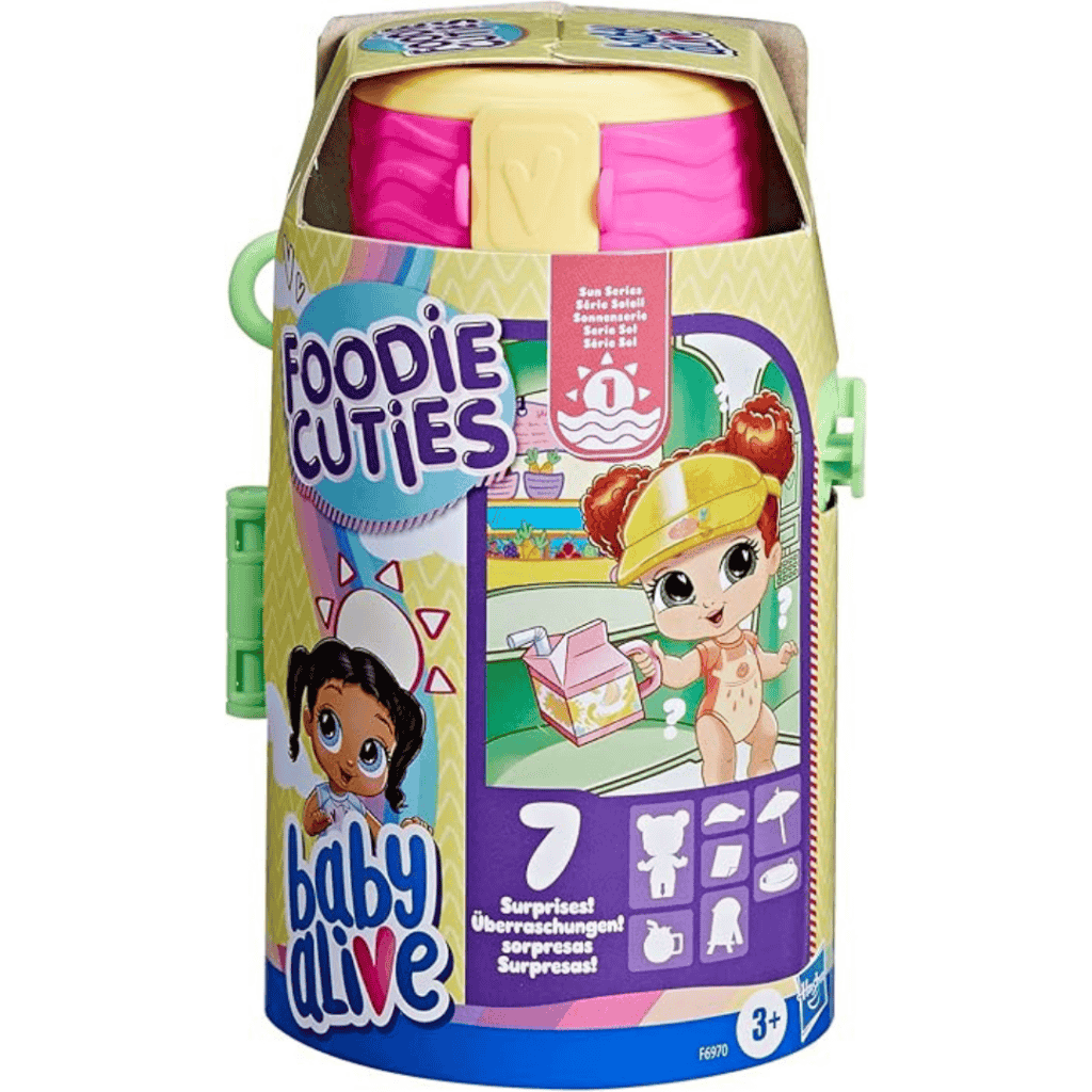 The image showcases packaging for "Baby Alive Foodie Cuties," featuring a colorful design with illustrated characters and text indicating it contains seven surprises. Don't miss out on Friday Deals to delight kids aged 3 and up!