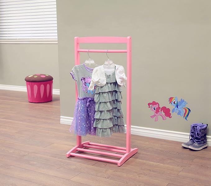 A pink clothing rack displays two children's dresses—one purple with stars and the other green with ruffles. Nearby, a pair of blue boots rests on the wooden floor, accented by colorful stickers on the wall. A cupcake-shaped stool sits by the window, perfect for enjoying Wednesday Deals.