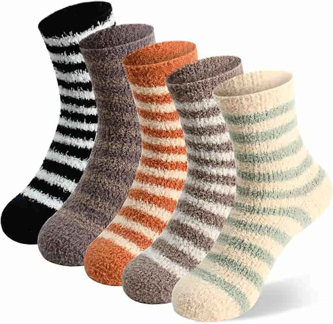 Five pairs of fuzzy socks are lined up for Monday Deals, showcasing distinct stripe patterns and colors: black and white, gray, brown, orange and cream, and beige and light green. Each pair looks incredibly soft and cozy.