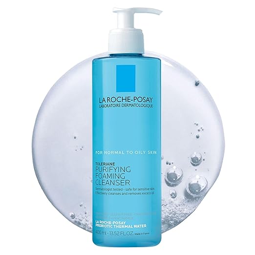 A blue pump bottle of La Roche-Posay Toleriane Purifying Foaming Cleanser for normal to oily skin, featured in front of a circular splash of water with bubbles. Labelled as dermatologically tested and 13.52 fl oz (400 ml), this product is a perfect pick for Thursday Deals.