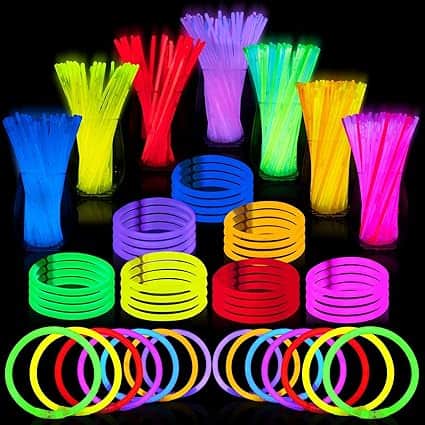 A vibrant assortment of multicolored glow sticks and glowing bracelets is displayed against a black background, featuring Friday Deals. The glow sticks are grouped by color: yellow, red, purple, green, and blue, with matching bracelets.