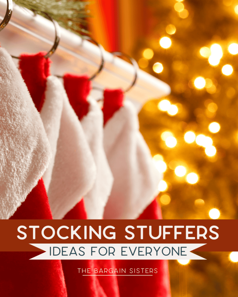 A row of red and white Christmas stockings hangs on a mantel next to a glowing Christmas tree. Text on the image reads, "Your List of Stocking Stuffers: Ideas for Everyone - The Bargain Sisters.