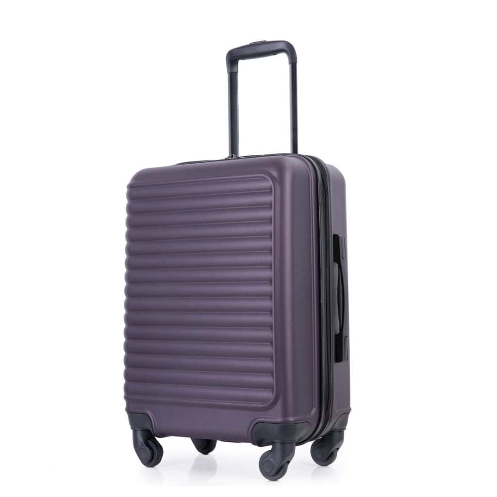 A sleek, dark purple hard-shell suitcase with a ribbed design offers elegance and practicality. Enjoy Friday Deals on this travel essential, featuring four black swivel wheels and a telescopic handle for effortless maneuvering. Its angled stance highlights the side handle and durable build.