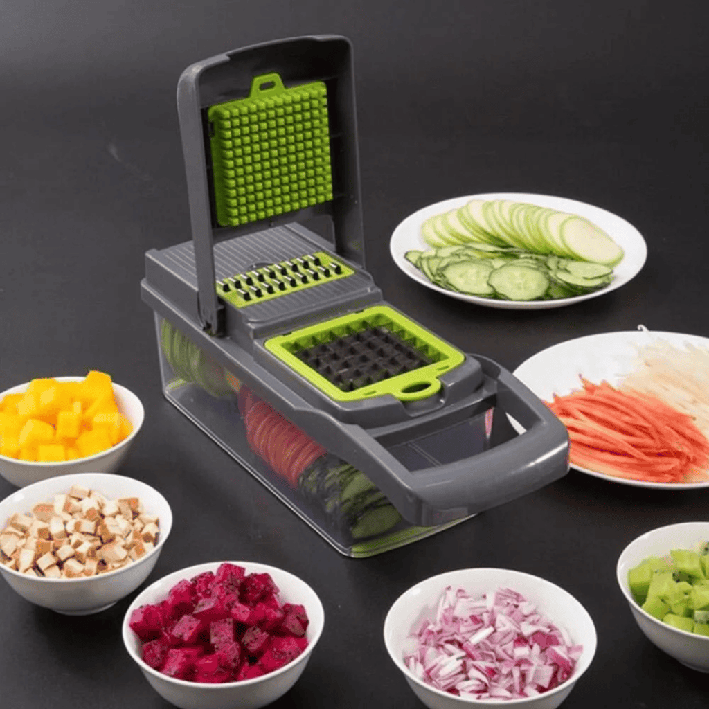 A vegetable chopper rests on a dark surface surrounded by diced and sliced vegetables like cucumber, carrots, onions, mushrooms, mango, dragon fruit, and avocado. Plates boast thin cucumber slices and shredded carrots—perfect for your kitchen needs. Don't miss out on Friday Deals to get yours!.