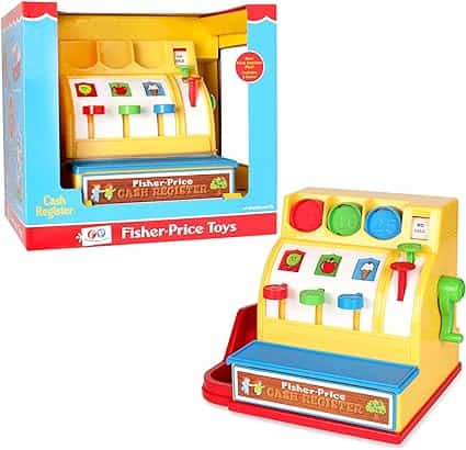 The Toy cash register by Fisher-Price, perfect for Friday Deals, comes in colorful packaging. It features four coin slots with fruit and number images, vibrant buttons, and a green lever. The predominantly red packaging includes branding and a window display that's sure to catch the eye.