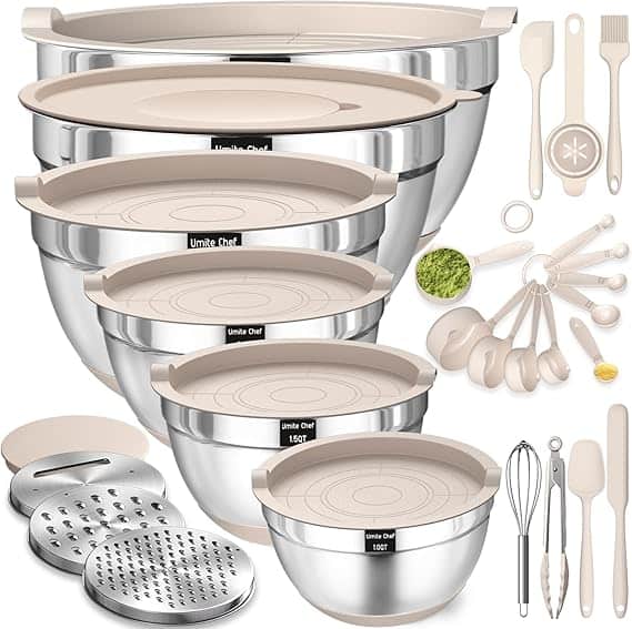 A set of four stainless steel mixing bowls with beige lids stacked together, accompanied by kitchen utensils like spatulas, measuring spoons, a whisk, and graters, all displayed against a white background. Perfect for those Wednesday Deals!.