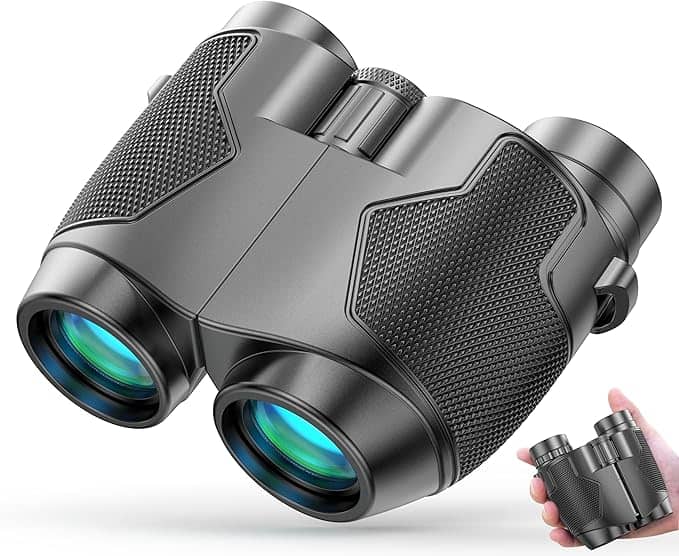 A pair of compact black binoculars with textured grips and blue-tinted lenses, perfect for Thursday Deals. A hand holds them, demonstrating their portable size.