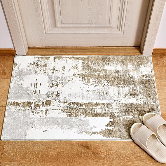 A doormat with an abstract beige and white design enhances the entrance in front of a wooden door. Light-colored slippers rest on the mat, set on a wooden floor, reminding you to seize Wednesday Deals for similar home essentials.