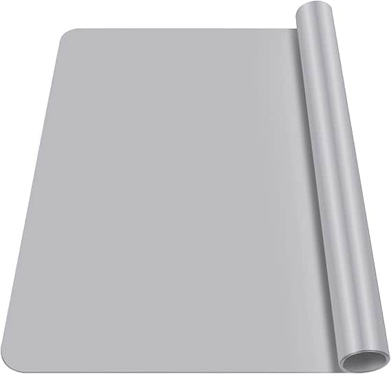 A roll of light gray silicone baking mat is partially unrolled, revealing its smooth and flexible surface. With rounded edges, the mat appears thick and durable—ideal for non-stick baking or food preparation. Grab it during Wednesday Deals for an extra kitchen upgrade!.