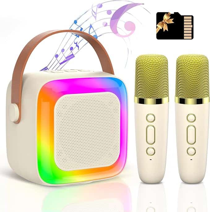 A white portable karaoke machine with a brown handle and colorful LED lights is accompanied by two gold microphones. An SD card floats above, with musical notes dancing in the background, all set to elevate your Monday Deals experience.