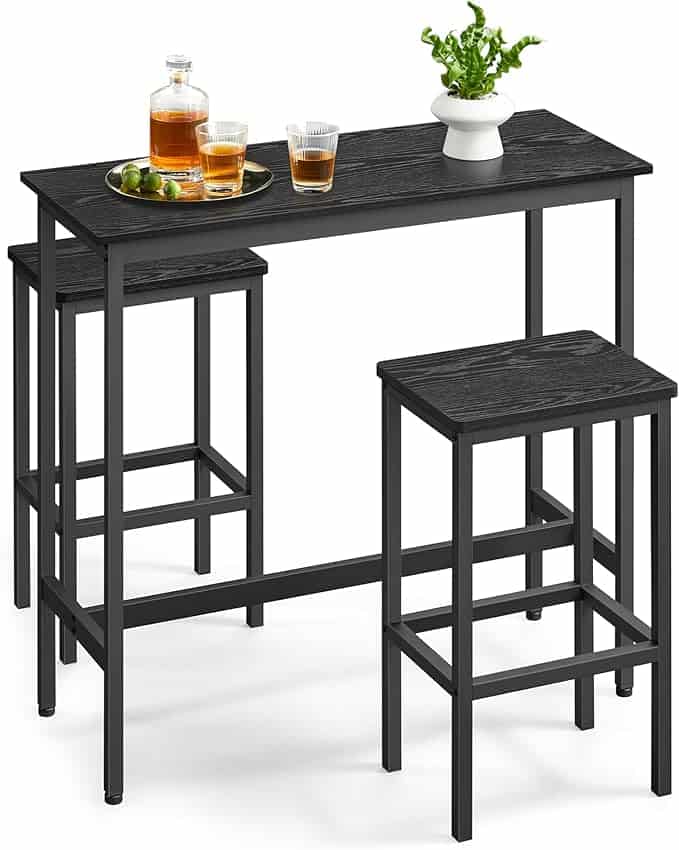 Discover Thursday Deals on this sleek black bar table set with minimalist charm. Complete your space with two matching high stools and a stylish tabletop featuring bottles, glasses, a plant, and a lime-laden tray—perfect for elevating any occasion against its crisp white backdrop.