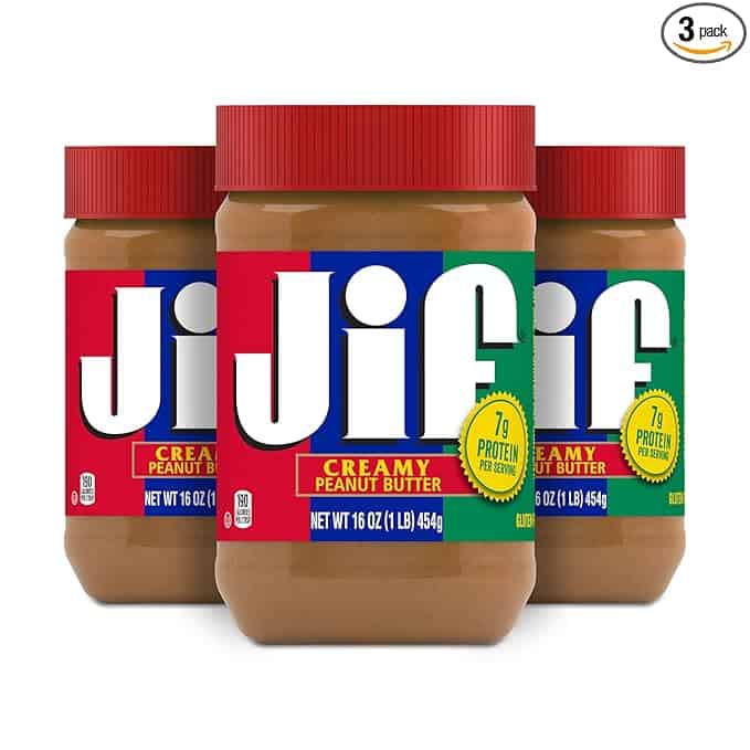 Three jars of Jif creamy peanut butter are displayed, each 16 ounces. The labels feature the iconic Jif logo on a red, blue, and green background. A yellow circle highlights "7g protein per serving." Capture this irresistible 3-pack during our Monday Deals!.