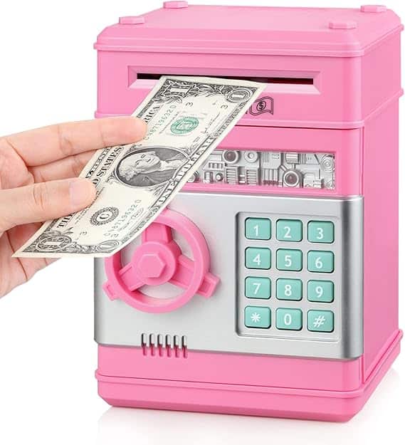 A pink toy ATM-like bank with a keypad and numbers. During Friday Deals, a hand slides a U.S. dollar bill into the top slot, unlocking savings through its round combination lock and handy coin slot.