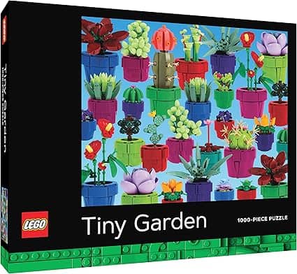 Lego puzzle box titled "Tiny Garden" showcasing an assortment of colorful plants in Lego pots against a blue background. With 1000 pieces, it's the perfect escape. Discover this delightful set in our Friday Deals for a blooming good time!.