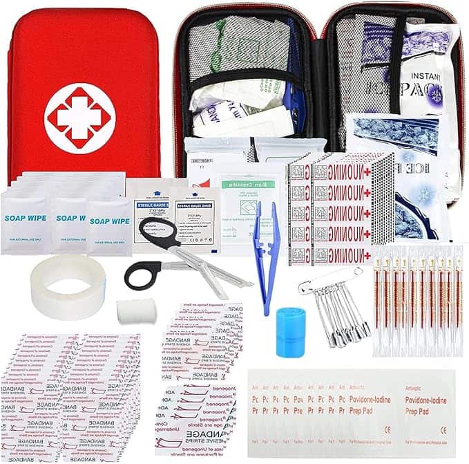 Contents of a first aid kit are spread out, showcasing bandages, wipes, gauze, tweezers, scissors, safety pins, adhesive tape—all neatly arranged beside a red case with a white cross. Don't miss out on Thursday Deals to snag these essentials for less!.