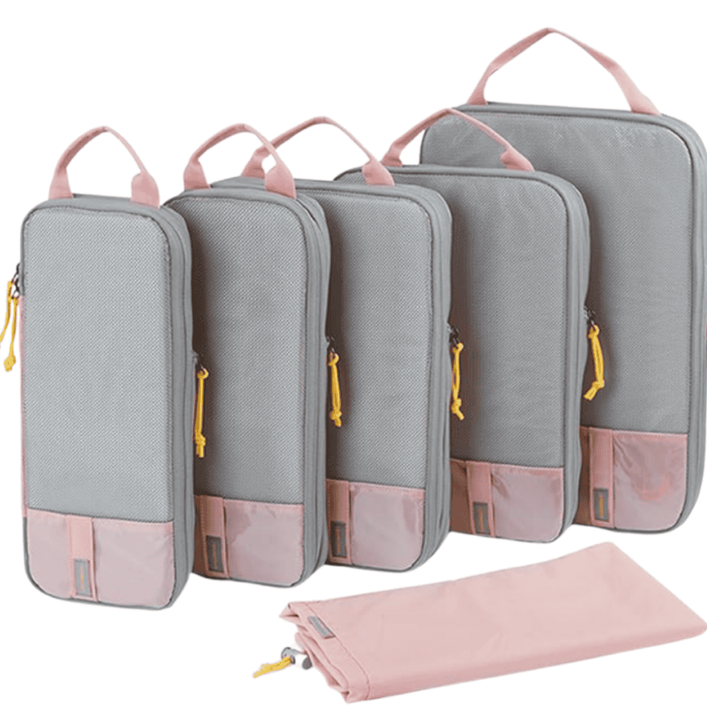 A set of five gray packing cubes with pink trim and yellow zipper pulls, arranged in a row from largest to smallest, offers great packing tips for organization. Each cube features a handy handle, with a matching pink drawstring bag stylishly placed in front.