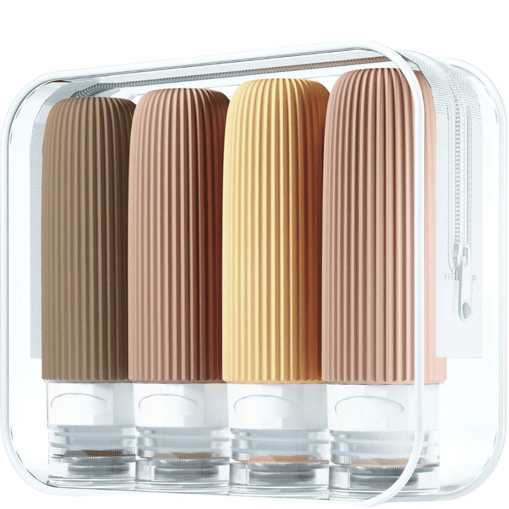 A set of four ribbed silicone travel bottles in shades of brown, orange, and pink is neatly arranged inside a transparent zippered toiletry bag with a white trim—perfect packing tips for organized travelers.