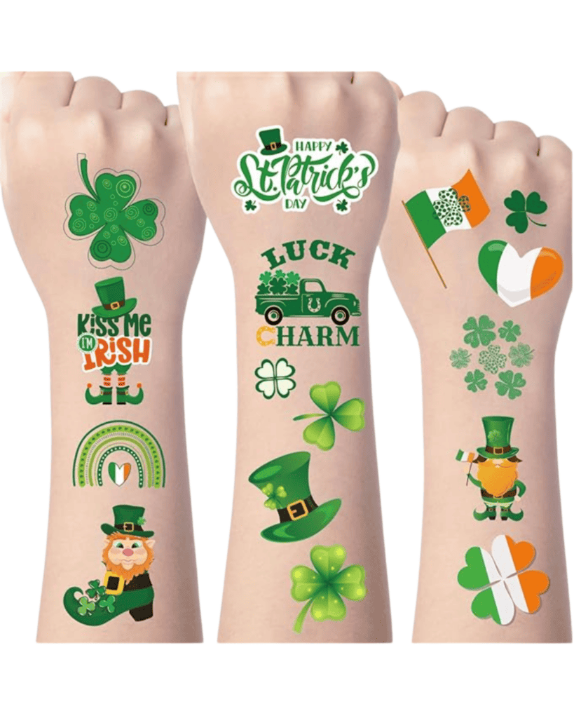 Three arms adorned with St. Patrick's Day-themed temporary tattoos, featuring shamrocks, leprechauns, rainbows, and phrases like "Kiss Me I'm Irish." These vibrant tattoos are perfect St. Patrick's Day accessories in green, orange, and white—matching the Irish flag colors.