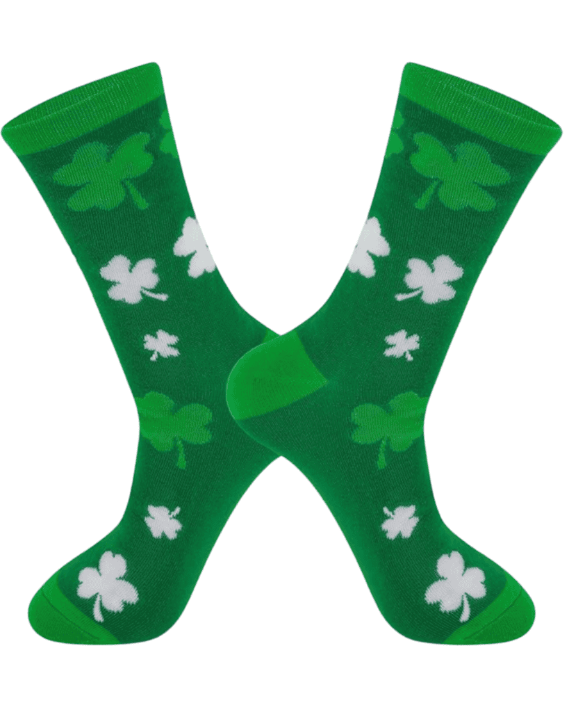 Green socks with a pattern of shamrocks in various sizes, perfect as St. Patrick's Day accessories. They feature both darker and lighter green tones, with reinforced heels and toes in solid green against a white background.